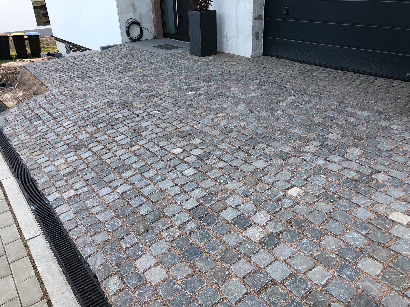 Melaphyr-Pflaster in Reihenverlegung – moderne Hauseinfahrt